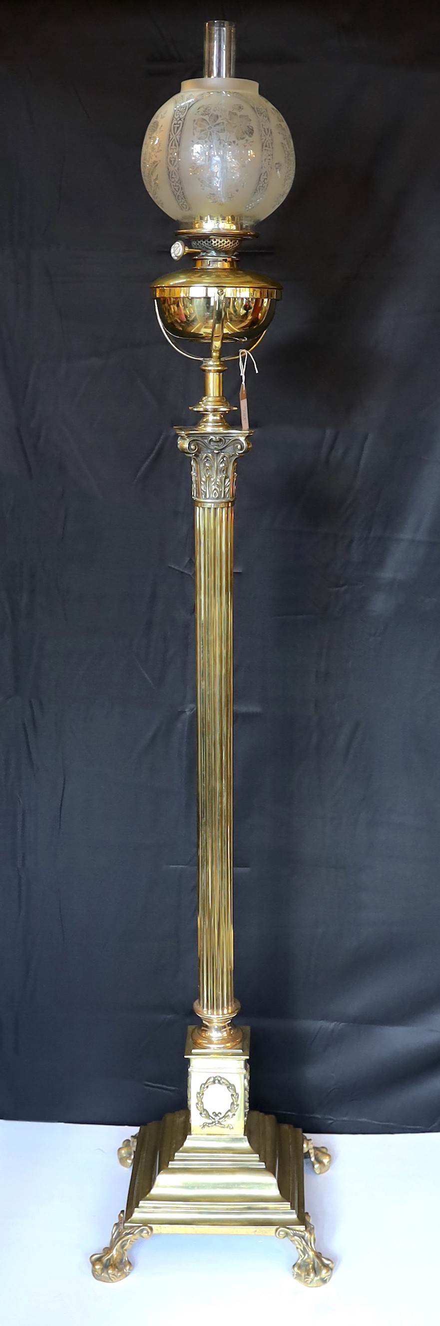 A Victorian brass Regency style print Corinthian telescopic oil lamp standard, with later etched glass globe and Williams & Bach of 92 New Bond Street London mechanism, height 170cm. width of base 34cm.